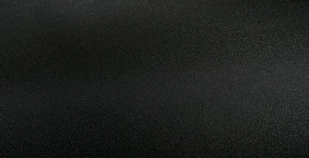 Visuel Cover Styl' : gros plan en lumière rasante sur le grain fin et mat du film noir K1