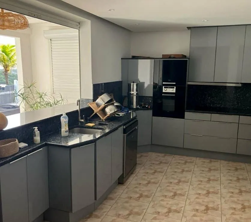 Cuisine en L aux façades gris anthracite, plan de travail en granit noir, avant le chantier