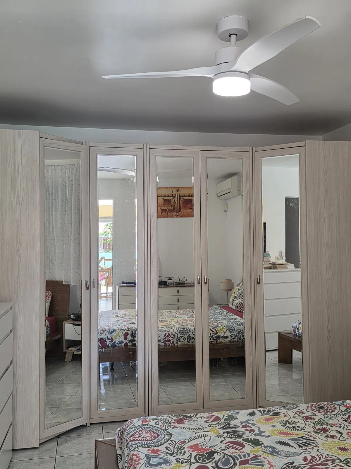 Dressing d'angle à portes miroir, encadrements en décor bois clair